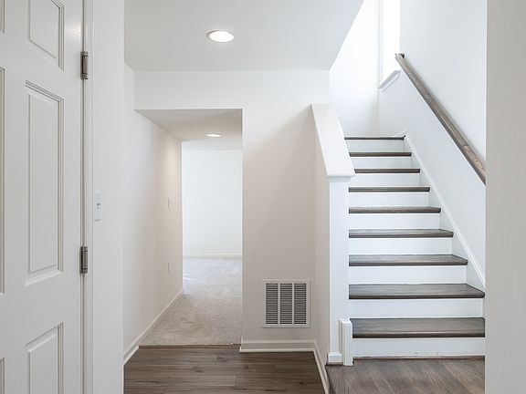 Foyer with a LVP staircase on the right and a hallway leading to the finished lower level on the lef