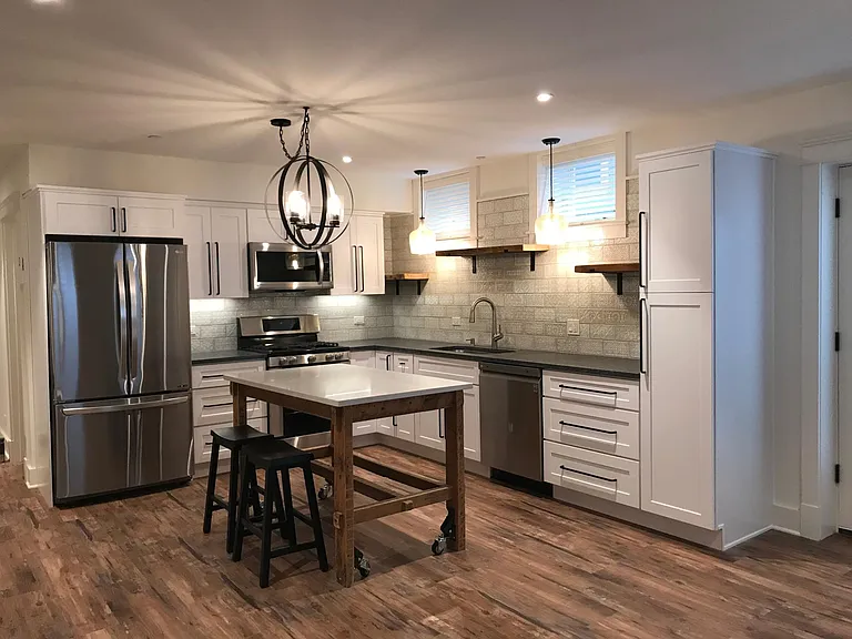Open concept Kitchen / Living Room with vinyl plank flooring and recessed LED lighting throughout