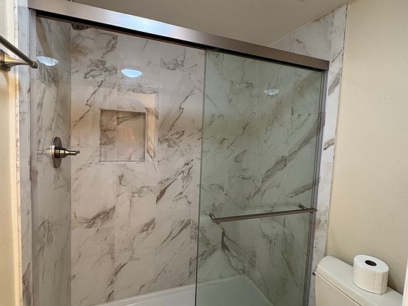 Master shower with porcelain tile enclosure, Delta shower hardware, Kohler bypass doors, Toto toilet