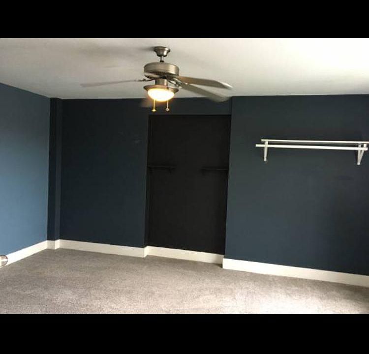 Bedroom with closet (not shown) and extra clothing rack.