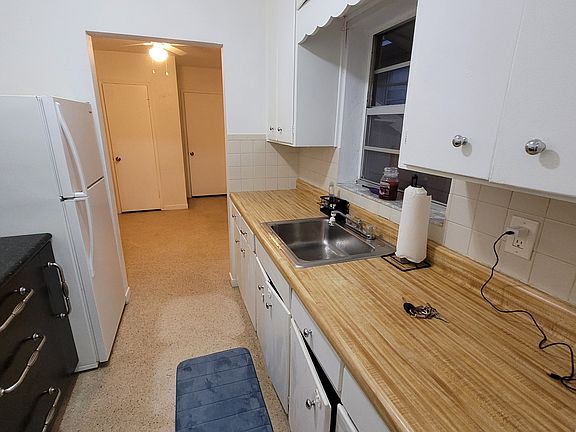 View into the kitchen looking from the direction of the back door, laundry room, and storage room.
