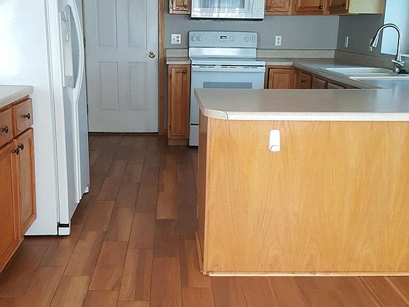 The kitchen is loaded with cabinets and workspaces. Refrigerator, range, microwave, garbage disposal, and dishwasher.