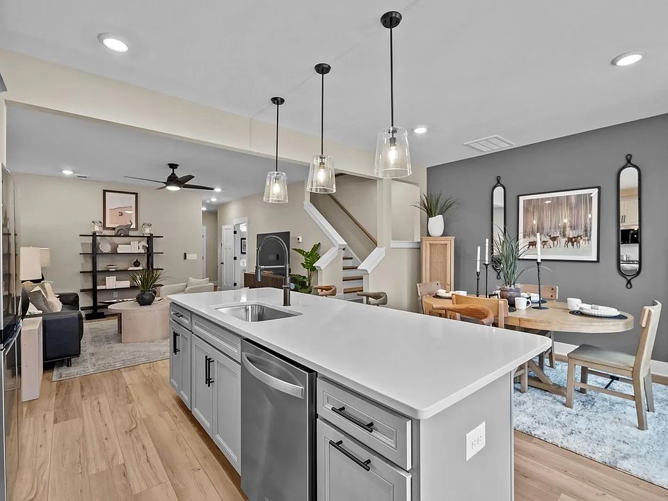 Light kitchen with large island and gray accents at Hickory Heights by DRB Homes near Downtown Green