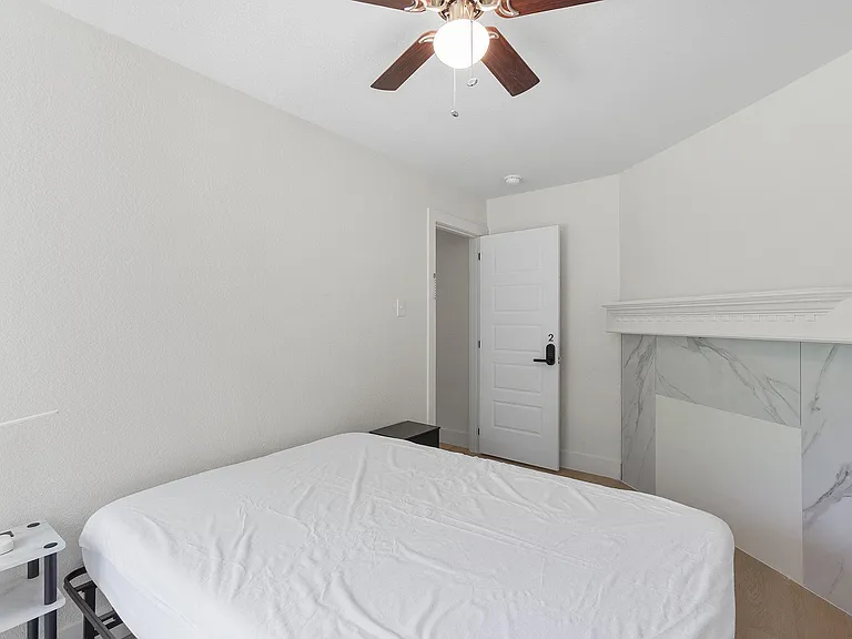 Private bedroom featuring a ceiling fan, neutral walls, and space for a full bed plus a nightstand or small dresser.