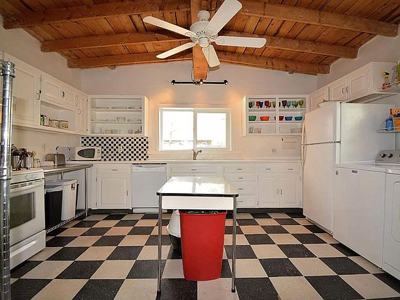 Oversized kitchen with plenty of storage and natural light from two windows. Washer/dryer, dishwasher, and corian counter tops. Charming wood ceiling and ceiling fan.