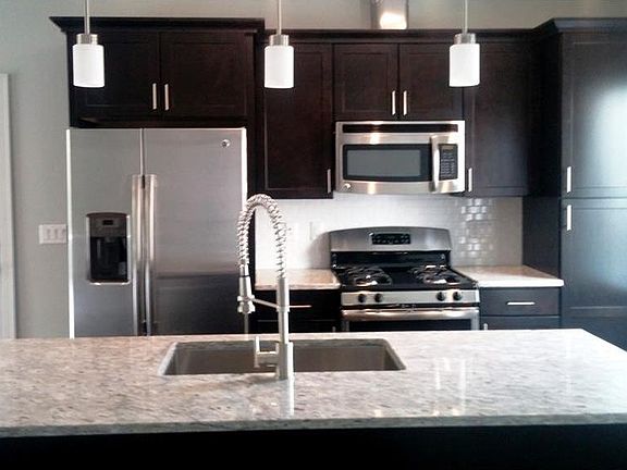 Kitchen side view, door pictured on left carries to private fenced patio space of end unit