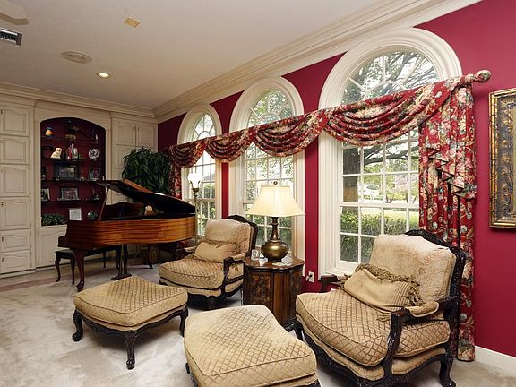 GRAND LIVING ROOM...Walls of windows. with beveled glass transoms. Custom cabinetry with glass shelv