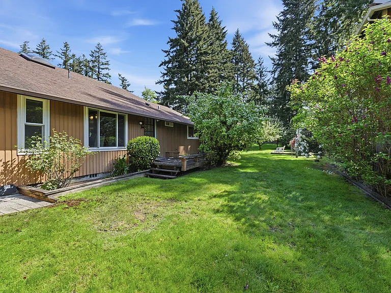 Side yard with mature fruit trees and flowering landscape