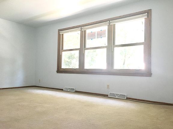 three giant windows in the living room overlooking the quiet