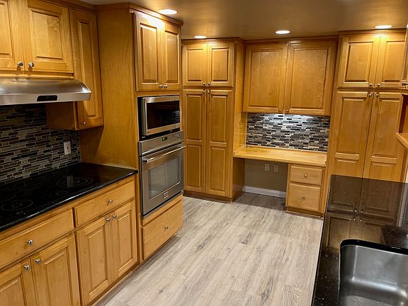 Kitchen with black granite countertops and built in desk
