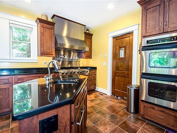 Kitchen island, view of original butlers door, double ovens and tons of natural light