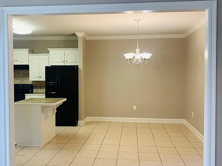 dining room area next to kitchen. crown molding throughout