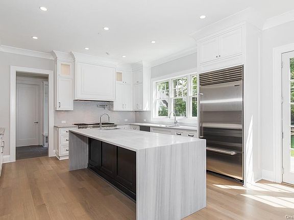 Kitchen - Kitchen with center island and waterfall edge quartzite