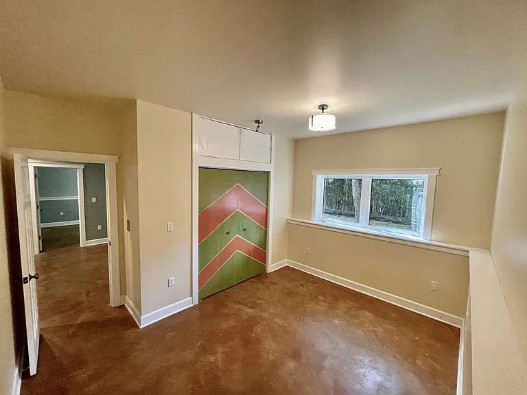 Bedroom 3 (Southwest) stained concrete floors stay cool all summer and warm in the winter with radiant floor heat. 11-12' ceilings throughout the home.