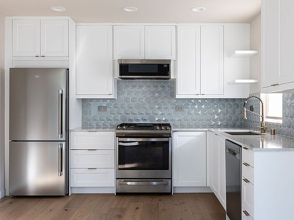 The kitchen is a dream with gas range, farmhouse-style sink, pull-down faucet, under-cabinet lighting, microwave--big pantry not shown