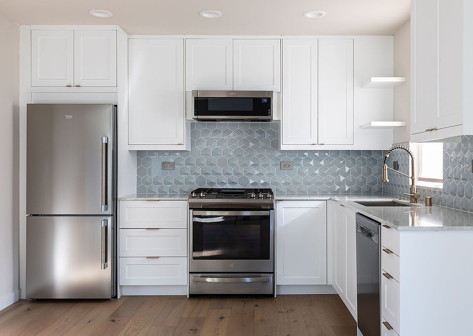 The kitchen is a dream with gas range, farmhouse-style sink, pull-down faucet, under-cabinet lighting, microwave--big pantry not shown