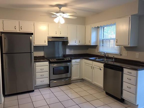 New stainless steel appliances and white tile floor. New washer/dryer located in utility closet.