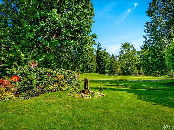 Large flat yard with beautiful mature landscaping and fountain.