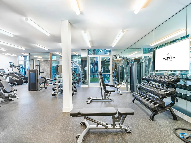 Modera Pomona offers a fitness center with cardio equipment, TRX system, and an interactive fitness mirror.