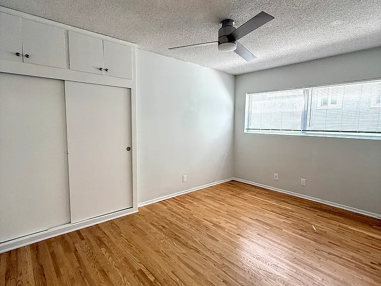 View of bedroom, closet and cabinets from the bedroom door.