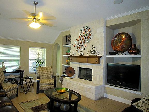 Fun in the family room which features a stone fireplace. Large niches on both sides for entertainment equipment and home decor.