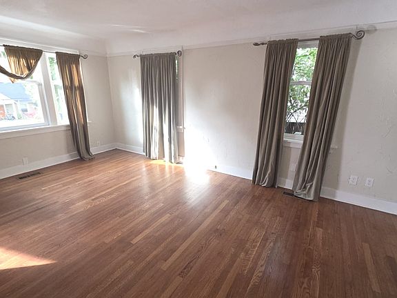 Large sunlight-filled living room with coved ceilings, real oak floors.