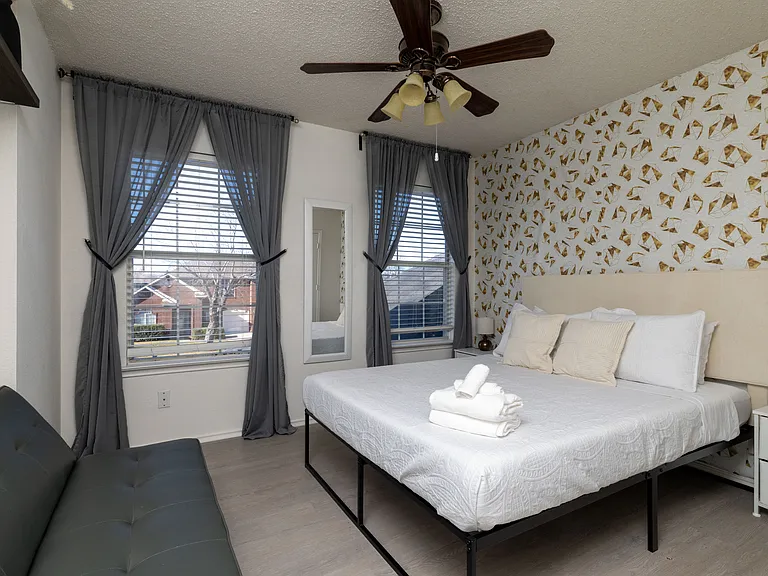 Bright bedroom with a stylish butterfly accent wall and queen-size bed.