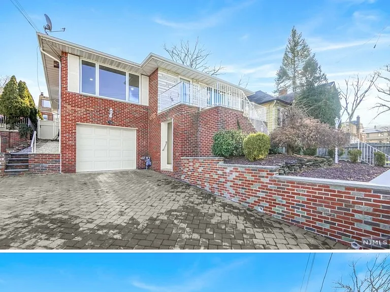 Exterior of home. One entrance upstairs, one downstairs next to garage door.