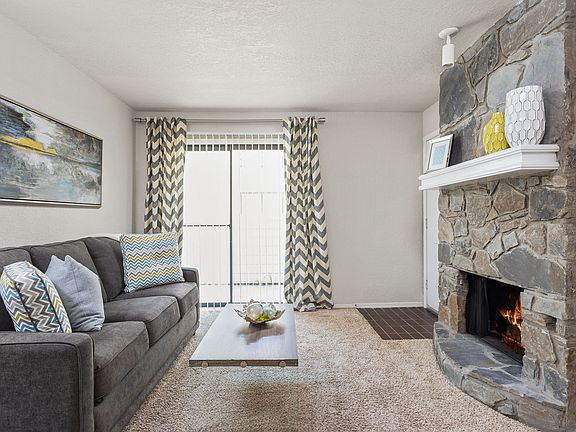 Living Room with Fireplace and Balcony Entrance - Windrush Apartments
