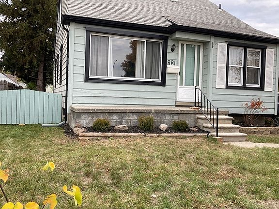Front of house , including fence and pines that give shade to the back of the home.