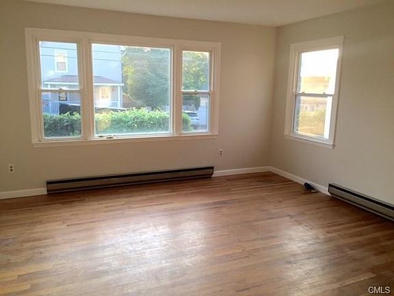 Light and bright living space with hardwood floors flowing t