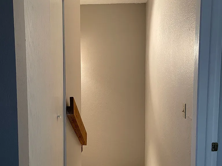 Hallway with linen closet and stairs heading down to main level.