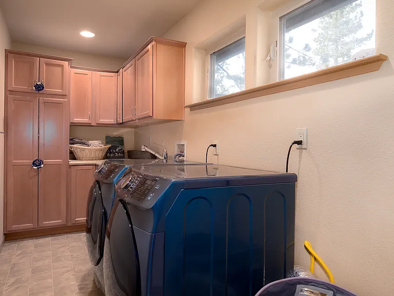 Laundry room with cabinets, at the top of the stairs.