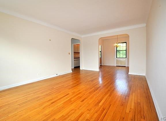 The living room has treetop views and overlooks the quiet courtyard. There are two arched opening, o