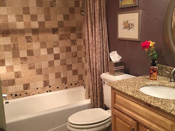 Guest bathroom - in hallway - granite shower and counter. Travertine tile throughout. Designer toilet!