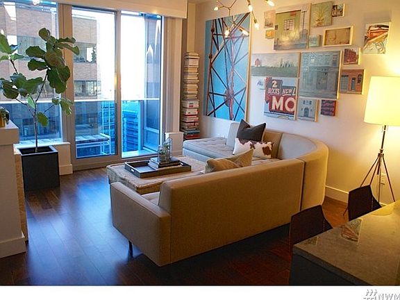 Airy great room design with wood floors, full wall of windows with city views and partial sound and mountain views.