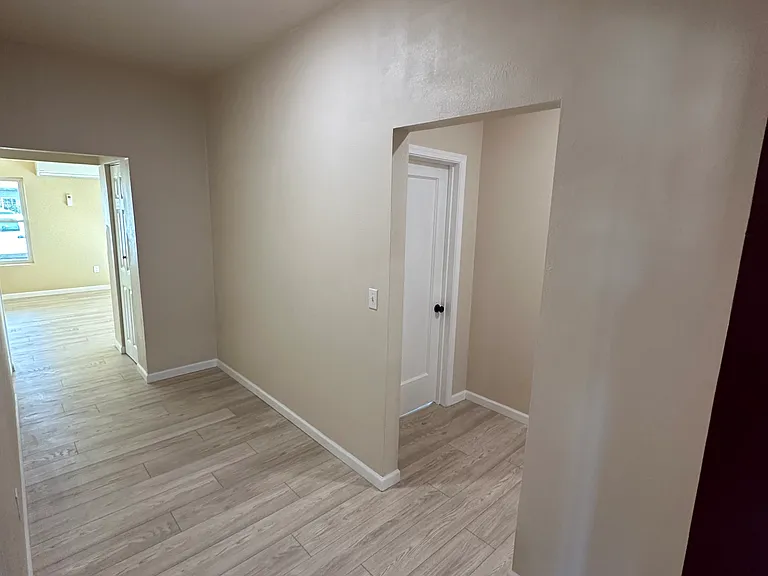 Looking from kitchen to hall to bedrooms and bathroom and to the left hall to living room washer dryer on the left and a coat closet on the right. This hallway is big enough for a computer desk and a portable pantry if you want.