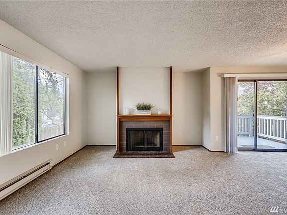 Living room with wood burning fireplace that has never been used by owner.  Wonderful private deck just off living space, great for entertaining or relaxing.