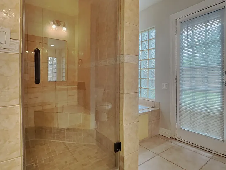 Warm, beige-tiled bathroom wit