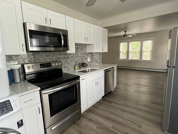 Kitchen with full fridge/freezer, electric oven and wash/dryer.