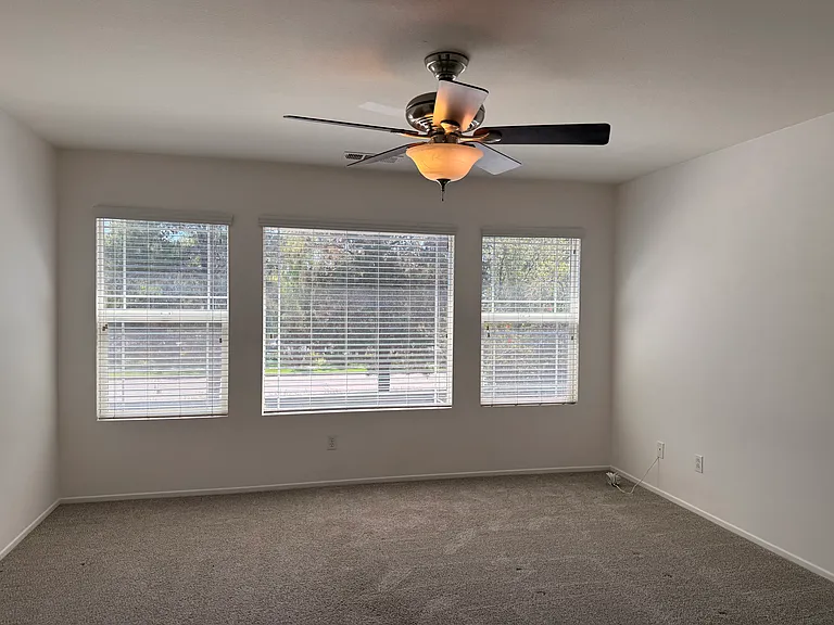 Primary bedroom, spacious with big windows and lots of light. Ceiling fan