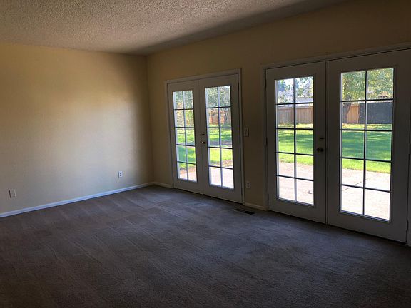 French doors in living room with view of backyard and patio