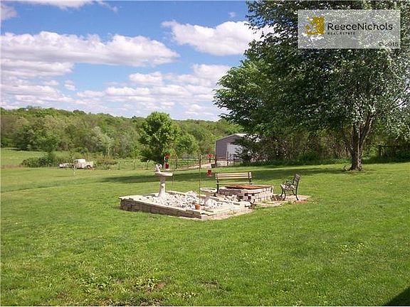 Looking SE at fire pit, pasture and out bldg