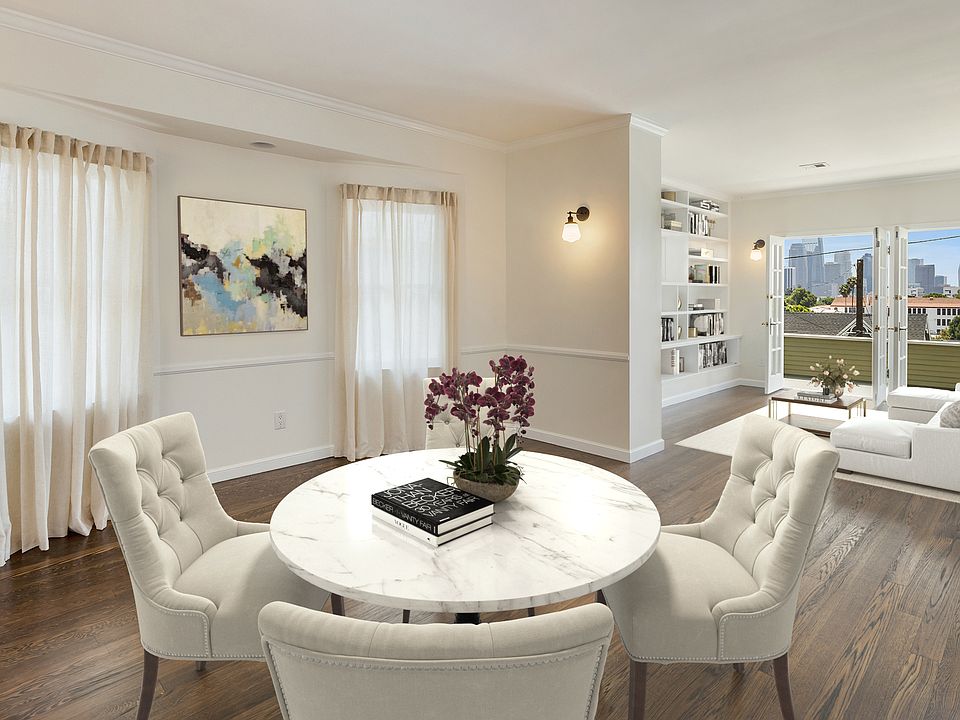 Living room / dining room with built ins, skyline views, private patio shown with example staging. Unit comes unfurnished
