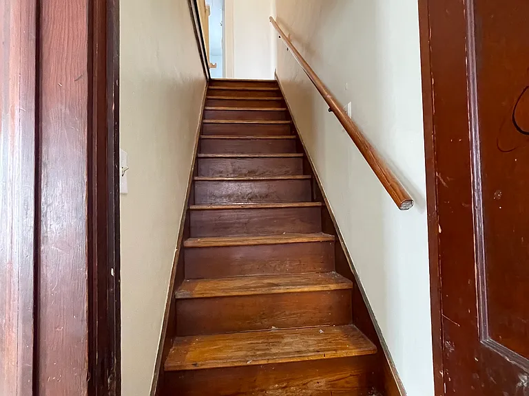 Stairway leading up to 3 bedrooms and bathroom.