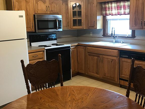 Cozy kitchen with refrigerator, range, microwave, and dishwasher.