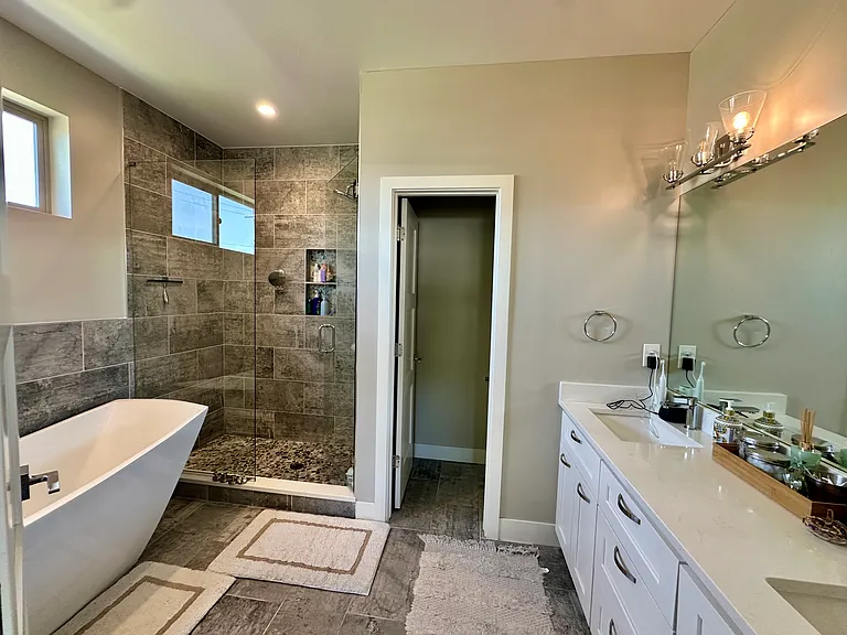 Primary bathroom with double vanity, private toilet room, shower & tub.