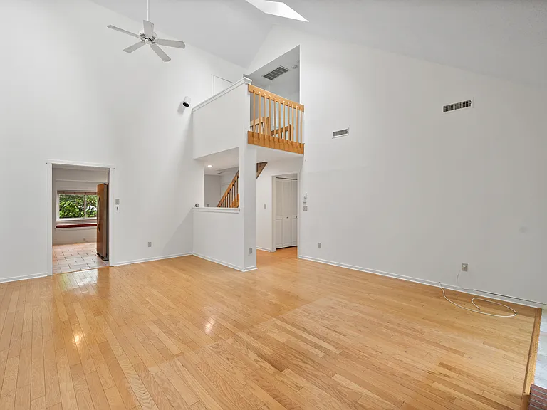 Living room with vaulted ceilings, large windows, and skylights