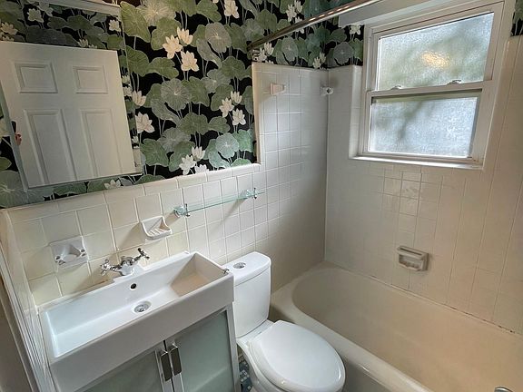 Efficient bathroom with under sink storage and extra-deep in-wall medicine cabinet.