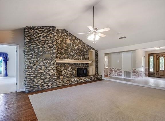 Stone statement wall.  Vaulted ceiling and one of the three living spaces.  Imagine cozying up to this fireplace on those chilly evenings in the Fall and winter.  Open to the dining and kitchen.  Great place to entertain.
